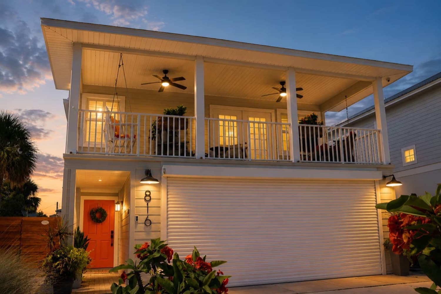 Inviting coastal home with a spacious wraparound-style porch at sunset